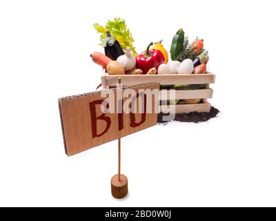 Légumes biologiques dans une boîte rustique en bois et un topsol avec étiquette carrée en carton. Étiquette de prix, étiquette cadeau, étiquette de vente, étiquette isolée sur fond blanc Banque D'Images