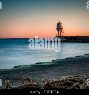 Le phare du village suédois Raa à la périphérie d'Helsingborg au coucher du soleil. Banque D'Images