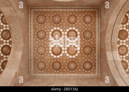 Beau plafond avec décoration en plâtre sculpté et murs en marbre. Détail architectural de la mosquée Hassan II à Casablanca, Maroc. Banque D'Images
