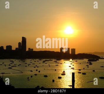 Le coucher du soleil dans la soirée est beau de Pattaya, Thaïlande, en regardant d'une autre côte à côté de la ville a trouvé un bateau de pêche et des bateaux pour de nombreux types de Banque D'Images