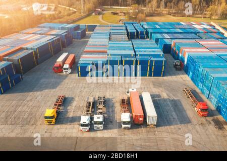 Vue aérienne des camions et des conteneurs au coucher du soleil. Vue de dessus Banque D'Images