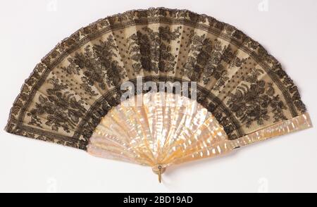 Ventilateur plissé. Recherche en ventilateur ProgressPleated. Feuille de dentelle noire en lin Chantilly dans le motif montrant des bunches de fleurs entre les frontières des feuilles. Dos en soie blanche. Bâtonnets de nacre. Ventilateur plissé Banque D'Images