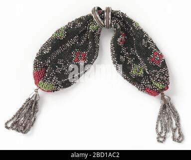 Sac à main Misers. Recherche sur la soie noire ProgressCroched brodée de petites carrés rouges et verts, esquissée en perles d'acier. Plus de perles d'acier forment des barres et des croix. Fermeture latérale contrôlée par deux anneaux en acier ; glands en perles d'acier à chaque extrémité du sac à main. Sac à main Misers Banque D'Images