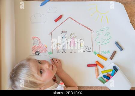 Les enfants dessinant une famille heureuse à l'intérieur de la maison Banque D'Images