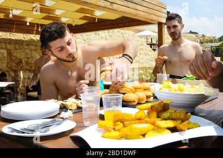 Jbeil, Liban - 28 mai 2017 : des hommes qui ont de la nourriture dans un restaurant. Banque D'Images