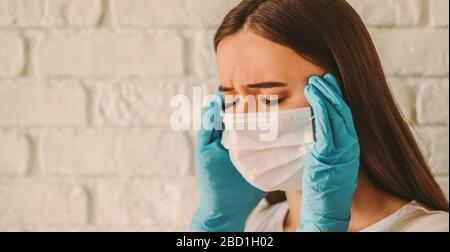 Une femme de sexe féminin, épuisée, est stressée dans un masque de protection sur le visage et des gants médicaux souffrant de maux de tête. Femme malade fatigué dans le masque médical et Banque D'Images