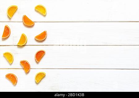 La marmalade aux fruits multicolores repose sur un fond en bois blanc Banque D'Images