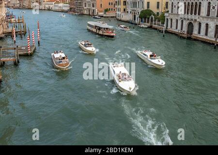 Des bateaux-taxis et un vaporetto ou un bateau-bus naviguant le long du Grand Canal, Venise, Italie Banque D'Images