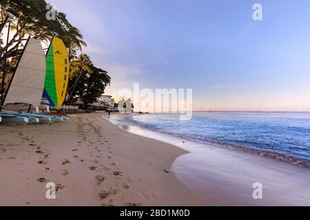 Baie de Paynes au lever du soleil, bateaux à voile colorés sur plage de sable rose, belle côte ouest, Barbade, îles Windward, Caraïbes Banque D'Images