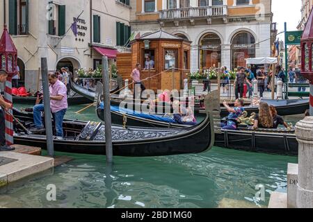 Touristes assis à Gondolas à la station de télécabine de San Moise à Campo San Moise , près de la place Saint Marc, Venise, Italie Banque D'Images