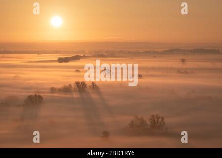 Le lever du soleil sur la brume couvrait les niveaux de Somerset en hiver, près de Glastonbury, Somerset, Angleterre, Royaume-Uni, Europe Banque D'Images