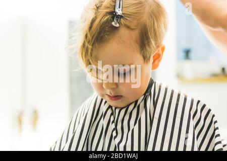 Un petit garçon dans un salon de coiffure Banque D'Images