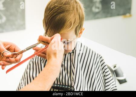 Un petit garçon dans un salon de coiffure Banque D'Images