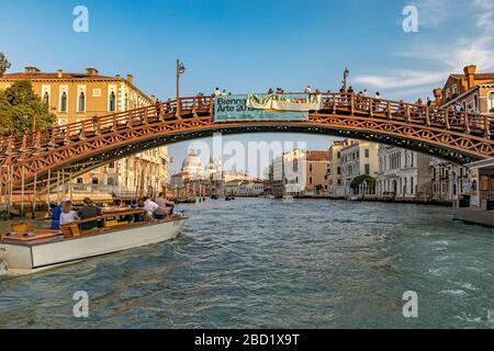 Un bateau-taxi passe sous le pont de l'Accademia ou le Ponte dell'Accademia qui relie le quartier de San Marco à Dorsoduro, Venise Italie Banque D'Images