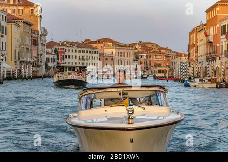 Gros plan sur un bateau-taxi et son chauffeur navigue le long du Grand Canal à Venise, en Italie Banque D'Images