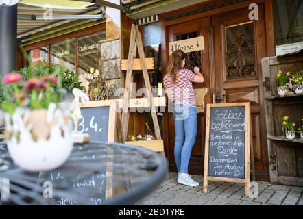 06 avril 2020, Bade-Wuerttemberg, Künzelsau: Une femme boutique de fleurs à la caisse libre-service. Pour ralentir la propagation du coronavirus, la vie publique est en grande partie fermée. Photo: Sebastian Gollnow/dpa Banque D'Images