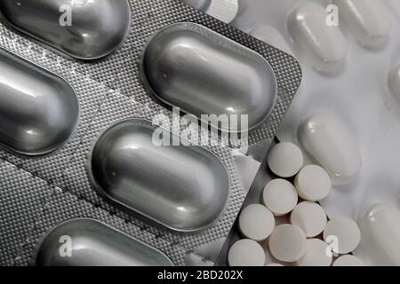 Médicaments et pilules,comprimés en plaquettes thermoformées et en vrac pris à proximité sur fond blanc au Royaume-Uni Banque D'Images