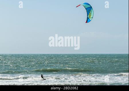 Garrettstown, West Cork, Irlande. 6 avril 2020. Un surfeur kite profite des vents forts et des grandes vagues de Garrettstown Beach tout en observant les directives du gouvernement en matière de distanciation sociale pendant la pandémie de Covid-19. Crédit : Andy Gibson/Alay Live News Banque D'Images