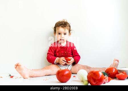 Un Bebe Pieds Nus Joue Aux Tomates Rouges Pitiches Et Frotte Son Jus Photo Stock Alamy