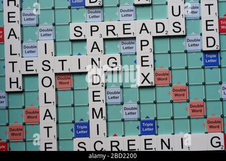 Mots liés au coronavirus énoncés sur un tableau de Scrabble. Image conceptuelle pour les articles éditoriaux covid-19. Avec mise au point sélective. Banque D'Images