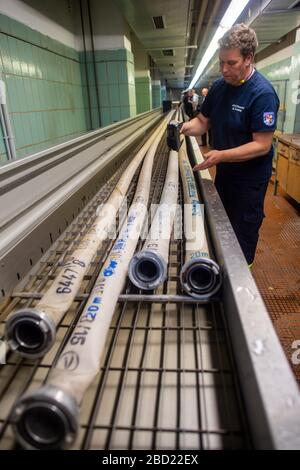 06 avril 2020, Saxe-Anhalt, Arneburg: Hubert Buddy du centre technique de la brigade des pompiers (FTZ) dans le district de Stendal marque la date de l'essai sur un tuyau d'incendie lavé et testé avec un cachet. Les nouveaux flexibles sont stockés dans la FTZ et les anciens flexibles sont testés et lavés. Dans l'après-midi, la station de lavage des tuyaux reconvertis de la FTZ a été mise en service. Le lavage des tuyaux est essentiellement le lave-linge pour les tuyaux d'incendie. Le FTZ nettoie et teste environ 10.000 de ces tuyaux d'incendie par an. Dans le district de Stendal, jusqu'à 16 000 tuyaux sont utilisés par les pompiers. Chaque flexible doit être lavé après chaque de Banque D'Images