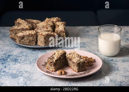 Tarte aux graines de pavot maison avec un verre de lait sur une table rustique, petit déjeuner ou dessert, tarte traditionnelle au pavot avec noix hachées et confiture d'abricot Banque D'Images