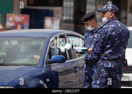 Bethléem, Mideast. 6 avril 2020. Un policier palestinien interroge un conducteur lors d'une campagne pour saisir des conducteurs qui violent la loi d'urgence dans la ville de Bethléem, en Cisjordanie, le 6 avril 2020. La Palestine a déclaré lundi que le verrouillage complet de quatre villages en Cisjordanie, puisque les affaires COVID-19 en Palestine ont grimpé à 252. Crédit: Luay Sababa/Xinhua/Alay Live News Banque D'Images