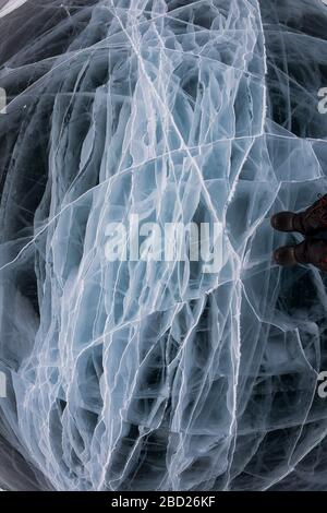 La glace grise du lac Baikal dans de nombreuses fissures blanches près de la ressource graphique d'arrière-plan. Banque D'Images