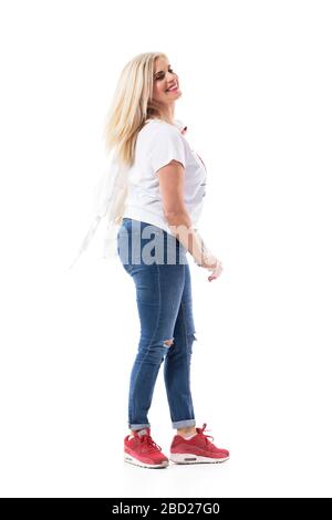 Vue latérale de la vitalité active âge moyen décontracté femme tournant et sourire regardant loin. Longueur totale du corps isolée sur fond blanc. Banque D'Images