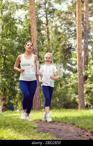 sport de course mère et fille. femme et enfant jogging dans un parc. sports de plein air et remise en forme en famille. Banque D'Images