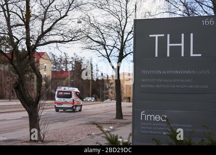 Helsinki, Finlande - 4 avril 2020: Signe extérieur de l'Institut national finlandais de la santé et du bien-être social (THL) avec une ambulance passant sur Mannerh Banque D'Images