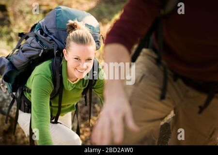 Portrait d'une jeune femme adulte escalade avec un sac à dos à l'extérieur. Banque D'Images