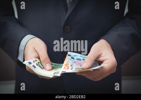 Homme en costume compte les billets en euros. Affaires et finance, concept de salaire Banque D'Images