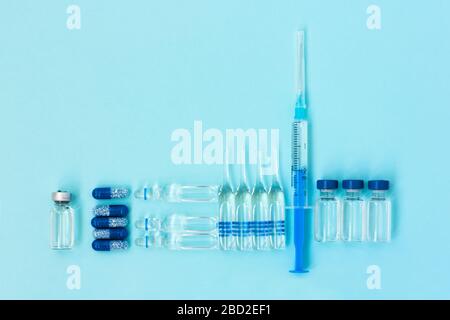 Thermomètre, pilules, ampoules à injection, seringue pour la vaccination sur fond bleu, coronavirus de santé, cancer, douleur et traitement, pharmaceutique Banque D'Images