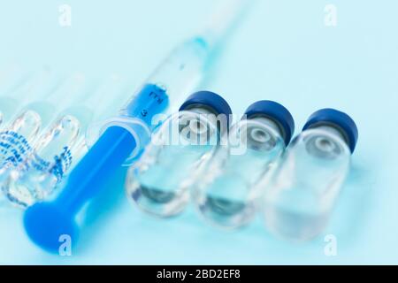 ampoules à injection, seringue de vaccination sur fond bleu, coronavirus de santé, cancer, douleur et traitement, concept de médecine pharmaceutique Banque D'Images