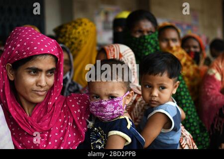 Les sans-abri bangladais attendent dans une file d'attente d'obtenir de l'aide pendant le verrouillage national imposé comme mesure pour empêcher la propagation de COVID-19, à Dhaka Banque D'Images
