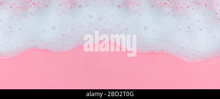 Mousse de savon blanche avec bulles sur fond rose Banque D'Images