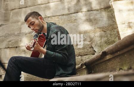 Charmant jeune musicien de rue avec guitare Banque D'Images