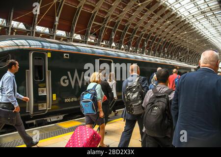 LONDRES, ANGLETERRE - JUILLET 2018 : les gens marchant le long d'une plate-forme à la gare de Paddington de Londres pour monter dans un train après l'annonce du numéro de la plate-forme. Banque D'Images