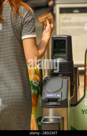 LONDRES, ANGLETERRE - JUILLET 2018 : vue rapprochée d'une personne utilisant une barrière automatique de billet sur le hall de la gare de Paddington à Londres. Banque D'Images