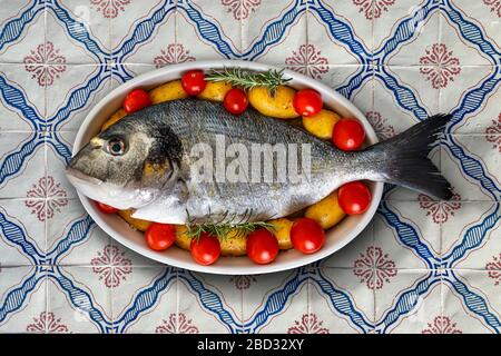 Un petit déjeuner de mer sur plat avec pommes de terre et tomates Banque D'Images