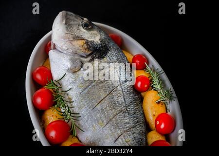 Un petit déjeuner de mer sur plat avec pommes de terre et tomates Banque D'Images