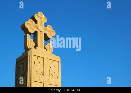 Magnifique pilier de la Croix de sculpture en pierre sur le ciel bleu vif, cathédrale Sainte-Trinité de Tbilissi, Géorgie Banque D'Images