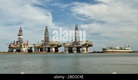 Harbour Island, Canyon Port, trois plates-formes de forage en eau profonde en stockage, à bord d'un bateau ancré, en attendant de décharger les pales de propulsion des turbines éoliennes géantes. Banque D'Images