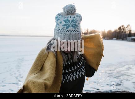 portrait d'une femme tenant un foulard tout en marchant sur un lac gelé Banque D'Images