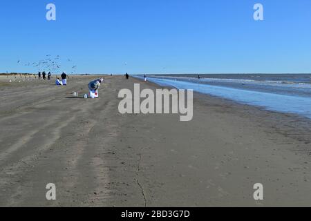 Des femmes noires en robes blanches prient sur la plage de Galveston, Texas Banque D'Images