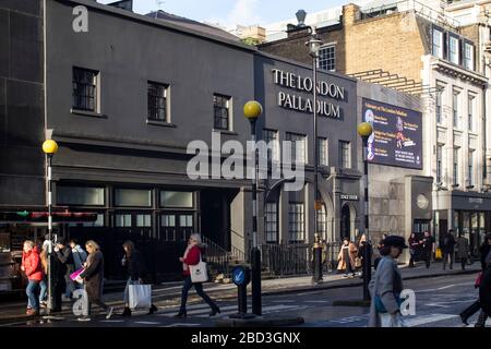 Londres, Royaume-Uni - 15 janvier 2020 , façade du London Palladium Theatre dans l'après-midi. Une grande foule de personnes traverse la route à un carrefour piétonnier Banque D'Images