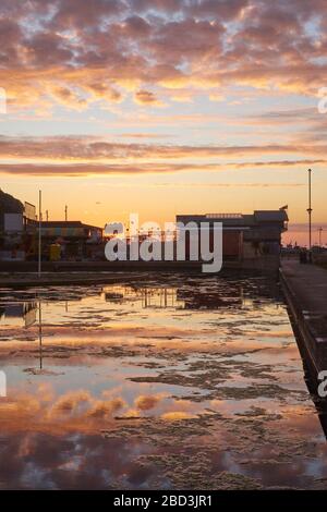 Hastings, East Sussex, Royaume-Uni. 6 avril 2020. Lever du soleil derrière le Life Boat House de l'autre côté du lac nautique. Banque D'Images