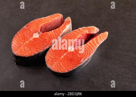 Deux steaks de saumon brut sur fond noir Banque D'Images