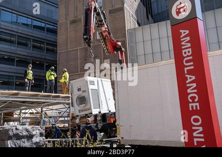 New York, États-Unis. 06 avril 2020. Au milieu d'un sommet prévu dans les décès de COVID-19, les travailleurs de la construction construisent une structure réfrigérée dans le parking ambulancier du NYU Langone Medical Center à New York, NY, États-Unis, le lundi 6 avril 2020. (Photo d'Albin Lohr-Jones/Sipa USA) crédit: SIPA USA/Alay Live News Banque D'Images